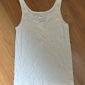 vitt linne med spets - vitt linne med spets vid urringningen . lappen är bortklippt och därför vet jag inte storlek (gassar på m eller l) eller märke 