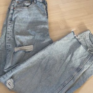 Jeans  -  ljusblå jeans med slitningar på benen, st 42 men små i storlek så passar 38/40