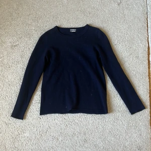 Mörkblå cashmeretröja från J.Crew - Säljer en klassisk mörkblå tröja från J.Crew i 100% kashmir. Tröjan har rund halsringning och långa ärmar, perfekt för en stilren och enkel look. Supermjuk och skön mot huden. ( den ser lite lortig ut på bilden men den tvättas såklart innan leverans)