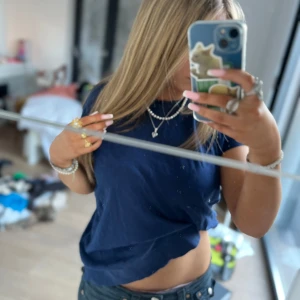 Mörkblå t-shirt - En enkel mörkblå t-shirt med rund halsringning. Modellen är normal passform och kortärmad, perfekt för en avslappnad stil. T-shirten är i ett mjukt material som känns skönt mot huden.