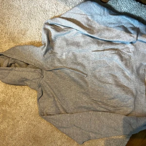 Grå Stussy hoodie   - Säljer en klassisk grå hoodie från Stussy i storlek M. Tröjan har huva, magficka och ribbade muddar. Perfekt för en avslappnad streetwear-look. Diskret Stussy-logga på bröstet. Nypris 1400kr