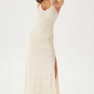 Balklänning Glittrig - Säljer denna oanvända balklänningen då jag har hittat en annan, den är ifrån märket YAS köpt på bubbleroom😍 köpt för 1600kr men säljer den billigare då jag vill hinna bli av med den innan balen🤗 Den har paljetter och knytning runt halsen, Ett fint släp och en lite öppnare rygg. Slits på ena benet. Vid fler frågor tveka inte på att kontakta mig!💕