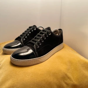 Lanvin toe cap - Jag säljer ett par svarat lanvin toe cap. Har använt dem i några veckor. En födelsedagspresent från familj. Dust bag ingår och box är bort tappad. Kan gå ner i pris vid snabb affär. Skriv om du har frågor angående exempelvis pris, bilder, etc. Mvh Emil