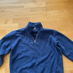 Blå fleece-tröja med dragkedja från Zara - Mysig blå fleece-tröja från Zara med halv dragkedja framtill och hög krage. Perfekt för kyliga dagar och enkel att matcha med jeans eller träningsbyxor.