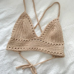 Beige virkad croppad linnetopp - Tillsammans med en kompis har vi virkat ett par gulliga toppar nu inför sommaren!  💖beige virkad croppad linnetopp med smala knytband och trekantsformade kupor. Toppen har ett öppet mönster längs kanten och under bysten, perfekt för sommaren! Kupa: 15 bred och 15 i höjd.