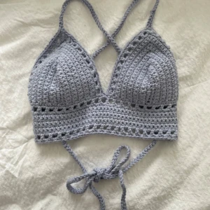 Ljusblå virkad croppad linnetopp - Tillsammans med en kompis har jag virkat ett par gulliga toppar nu inför sommaren!  💖ljusblå virkad croppad linnetopp med smala knytband och trekantsformade kupor. Toppen har ett öppet mönster längs kanten och under bysten, perfekt för sommaren! Kupa: 15 bred och 15 i höjd.