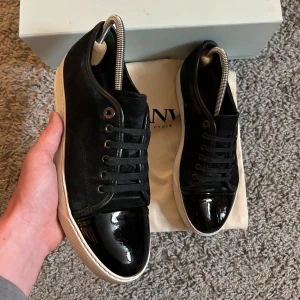 Lanvin Cap Toe skor - Säljer nu dessa trendiga svarta Lanvins i storlek 41 i ett mycket bra skick för endast 2499! Endast en liten crese finns på ena skon, annars är skicket prima. Box och dustbag på bild ingår även. Vid minsta lilla fundering är det bara att skicka DM!