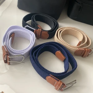 Färgglada flätade bälten med läderdetaljer - Säljer stilrena flätade bälten i olika färger: svart, beige, blå och ljuslila. Bältena har snygga bruna läderdetaljer vid spännet och är perfekta för att lyfta din outfit. Passar både jeans och andra byxor. 149kr st, 2st för 249kr och 4st för 399kr