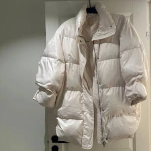 Vit pufferjacka från H&M - Säljer en vit pufferjacka från H&M i storlek XS. Jackan är vadderad och har lång ärm, hög krage och dragkedja framtill. Perfekt för kyliga dagar och ger en riktigt trendig look. Den hsr tvättats och blivit lite klumpig på insidan, men går fint att använda! 