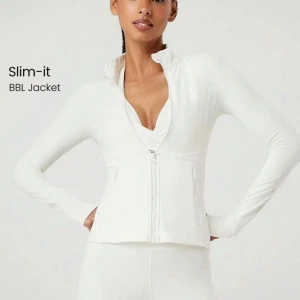 Vit Slim-it BBL träningsjacka glowmode - Snygg vit träningsjacka med figurnära passform och dragkedja framtill. Jackan har hög krage, långa ärmar och två fickor med dragkedja. Perfekt för träning eller en sportig look.