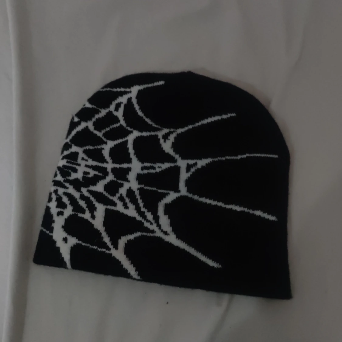 Svart mössa med spindelnätsmönster - 1