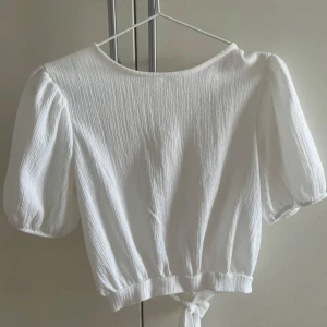  Blus med öppen rygg - Gullig blus från Monki som endast har använts 1 gång så mycket bra skick! Öppen rygg med knyte💗