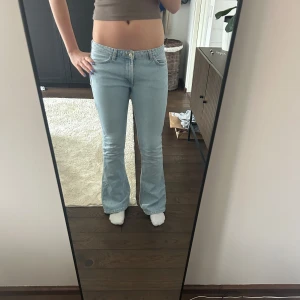 Ljusblå bootcut jeans - Säljer ett par ljusblå bootcut jeans med låg midja. Från Zara. Längst ner på byxan där bak är dem lite slitna 