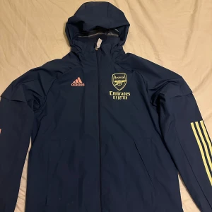 Arsenal jacka  - Säljer en blå vindjacka från Adidas med Arsenal-logga. 