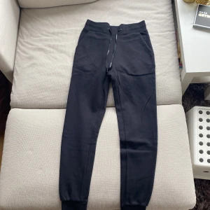 Svarta mjukisbyxor från Peak Performance - Svarta mjukisbyxor från Peak Performance med dragsko i midjan och muddar vid bensluten. Byxorna har en enkel och stilren design, perfekta för en avslappnad look. Tillverkade i mjukt material för extra komfort. (För små för mig)