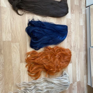Fyra färgglada peruker i syntet - Säljer fyra snygga peruker i syntetmaterial: en lång och rak brun, en marinblå med vågor, en orange med lockar och en ljusbeige med mjuka vågor. Perfekt för cosplays! Kan köpas som ett paket för 600kr men kan också köpas var för sig. Brun: 150kr orange:100kr blå:200kr beige: 150kr pris kan diskuteras vid snabb affär! 