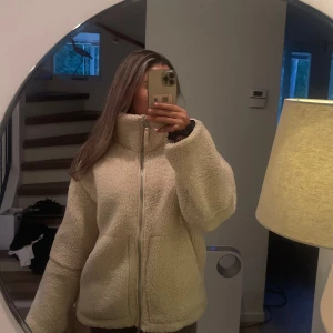 Trendig Teddy jacka från HM - Mysig beige teddyjacka med hög krage och dragkedja framtill. Jackan har två stora fickor och en oversized passform som ger en chill vibe. 💗