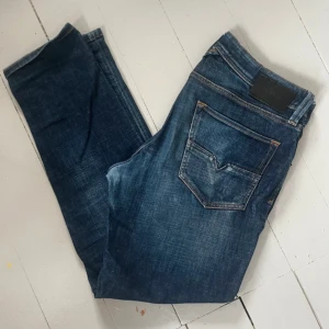Mörkblå jeansbyxor från disel - Snygga mörkblå jeansbyxor från Replay med klassisk femficksdesign och tydliga kontrastsömmar. Jeansen har en rak passform och är tillverkade i slitstarkt denimtyg. Perfekta för en avslappnad och trendig look.
