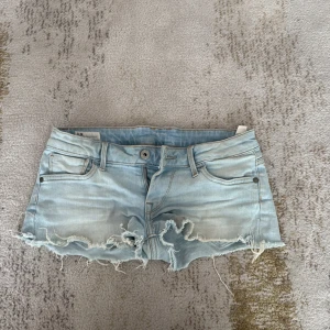 Ljusblå jeansshorts från Pepe Jeans - Snygga ljusblå jeansshorts från Pepe Jeans med råa, fransiga kanter och klassisk femficksdesign. Shortsen har låg midja och en avslappnad, loose passform. Shortsen är längre än vad de ser ut❤️ går inte att köpa orginallt längre💗