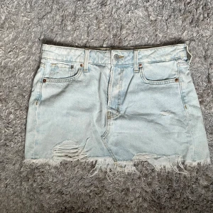 Ljusblå mini jeanskjol från ONLY - Ljusblå jeanskjol från ONLY i kort modell med slitna detaljer och fransig nederkant. Den är i storlek S och är i mycket bra skick.