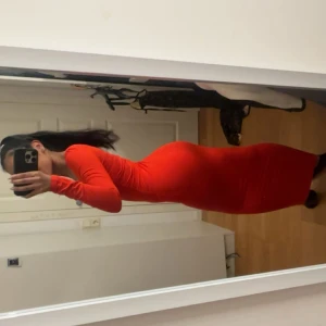 Röd långärmad klänning - Snygg röd långklänning från Gina Tricot med lång ärm och djup v-ringning. Klänningen är figurnära och stretchig, perfekt för dig som gillar en tight passform. Aldrig använts.