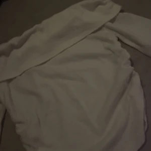 Vit offshoulder långärmad tröja - Säljer en vit långärmad tröja med offshoulder-design. Tröjan har en enkel och stilren look, perfekt för dig som gillar att sticka ut lite extra. Mjuk och skön att bära, passar till många olika outfits.