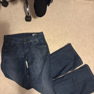 Blå bootcut jeans från Lee W28 L31 - Säljer ett par klassiska blå jeans från Lee med bootcut-modell. Jeansen har fem fickor, snygga kontrastsömmar och normal passform. Perfekta till sneakers eller boots och tillverkade i slitstarkt denimtyg.