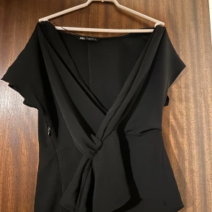 Svart omlottopp från Zara - Snygg svart omlottopp från Zara med korta ärmar och knyt framtill. 