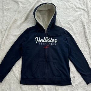 Hollister zip med foder  - En zip från Hollister i storlek L. Kan upplevas mindre i storlek. Tröjan bedöms vara i fint skick. Jag skickar ditt köp inom 24h. Se liknande zip i min profil! F95
