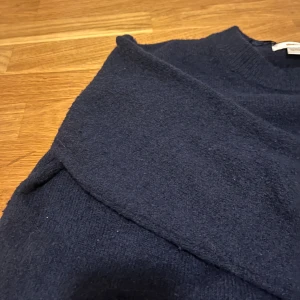 Mörkblå stickad tröja Gina Tricot - Mysig mörkblå stickad tröja från Gina Tricot i storlek 146/152. Tröjan har rund halsringning och långa ärmar, perfekt för kyliga dagar. Enkel och stilren design som funkar till många outfits.