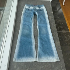 Blå bootcut jeans med fickdetaljer - Snygga jeans som jag köpte second hand. Midjemått tvärsöver: 38cm, midjehöjd: 18cm & innerbenslängd 78cm. Low waist 