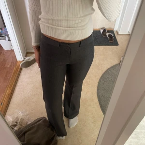 Grå kostymbyxor från Mango - Snygga grå kostymbyxor från MNG i storlek 36. Byxorna har en klassisk rak passform med utsvängda ben och low waist. Knappt använda🤍