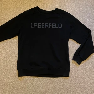 KARL LAGERFELD - Säljer denna snygga tröja från Karl Lagerfeld! Tröjan är mörkblå och i storlek L! Passar dig mellan 180-190!