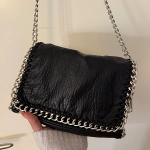 tiamo väska  - jättefin väska från tiamo som man kan ha snett över kroppen, man kan även snurra bandet så man kan ha den över ena axeln. 