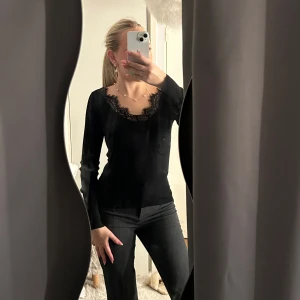 Svart topp - Svart långärmad ribbad topp med v ringning och spets. Superfin och sällan använd