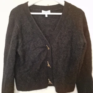 Svart kofta från & Other Stories - Säljer en supermjuk kofta från & Other Stories i ull och alpacka. Koftan har söta dinosaurier-knappar. Finns ej att köpa längre. Använd vid 1 tillfälle, så gott som ny och behöver hitta ett hem där den blir använd 🖤