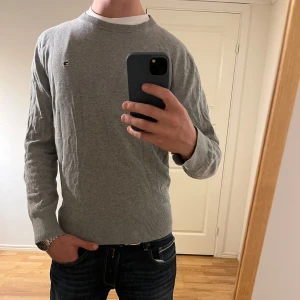 Grå stickad tröja Tommy Hilfiger   - Säljer denna sjukt snygga stickade tröjan från Tommy Hilfiger🌟Färgen är grå och storleken är L fits M🙌 Tröjan har inga defekter och i utomordentligt bra skick✅Riktigt najs passform och priset är inte hugget i sten🤝 Tveka inte på att höra av dig vid minsta fråga eller fundering🍁