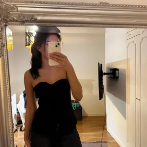 Svart jeanskjol från Denim Rebel/minikjol - Säljer en svart, tight jeanskjol från Denim Rebel. Kjolen är kort med rå kant nertill för en edgy vibe och har klassiska jeansdetaljer som knappar och fickor. Perfekt att matcha med crop tops eller hoodies för en cool look.. man kan klippa den kortare även