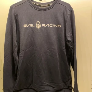 Sail Racing sweatshirt - Mörkblå sweatshirt från Sail Racing i väldigt bra skick inga defekter och knappt använd. Lite skrynklig pga den legat i min garderob. Öppen för prisförslag, vill få bort från min garderob då den inte passar min stil längre 😊