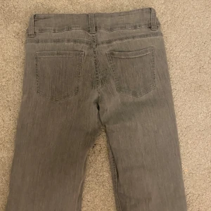 Gråa låg midjade jeans - Snygga grå jeansbyxor, de små märkena syns inte när man har på sig dem men ser såklart inte toppen ut på bild 💗
