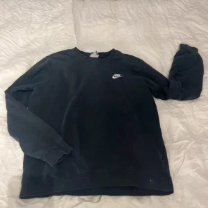 Svart sweatshirt från Nike - Säljer en klassisk svart sweatshirt från Nike med rund hals och långa ärmar. Perfekt för en avslappnad stil. Den har en liten vit Nike-logga på bröstet.