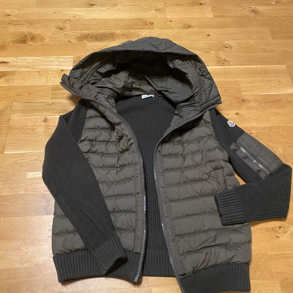 Snygg olivgrön jacka från Moncler med quiltad design och huva. Jackan har långa ärmar i ribbat material och dragkedja framtill. Perfekt för kyligare dagar. Jackan är i storlek L men sitter lite tajt så skulle nog säga att den passar mer som M. Har du minsta lilla fundering så är det bara att fråga på.. Takit.