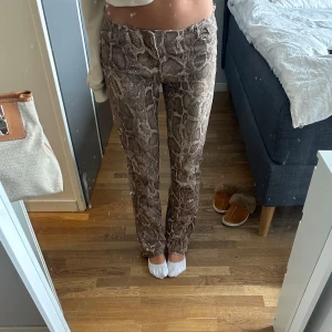 Mönstrade jeans - Snygga ormmönstrade jeans i bruna och beige toner. Lowwaist och ”Stockholmsstil”. Säljer på grund av att det blivit för små, är 167 och passar för storlek xs-s💕