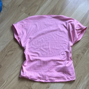 Rosa topp från Shein - Säljer en backless rosa topp från Shein. Den har en enkel design med korta ärmar och är tillverkad i ett mjukt material. Perfekt för en avslappnad stil.