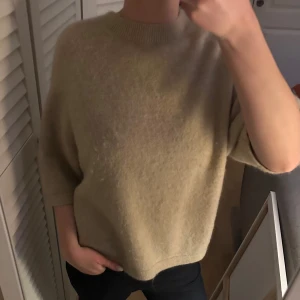 Beige tröja från & Other Stories - Säljer en stilren beige tröja från & Other Stories. Tröjan har en normal passform med trekvartsärmar och är tillverkad i ett mjukt material. Perfekt för en avslappnad look. Hör av dig vid intresse!