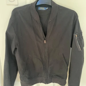 Svart Ralph Lauren jacka - Snygg svart jacka från Ralph Lauren som är perfekt till våren! Bra skick med inga synliga defekter och i storlek S. Skriv vid funderingar!! ❗️PRIS KAN DISKUTERAS❗️