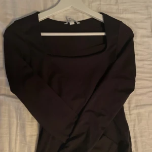 Svart långärmad klänning - Snygg svart långärmad klänning med fyrkantig urringning. Perfekt för en stilren look. Passar bra till både vardag och fest.