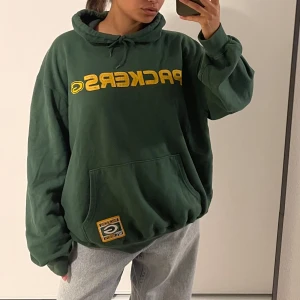 Packers hoodie - Säljer en Packers team hoodie i mörkgrön. Så cool och ger verkligen college vibe !! Storlek L men sitter fint som oversized på en S också