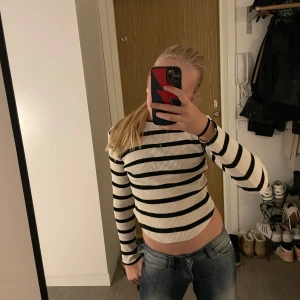 Randig ribbad tröja från Gina Tricot - Säljer en snygg randig tröja från Gina Tricot i svart och vit. Tröjan är ribbad och har en croppad passform med långa ärmar. Perfekt för en stilren look!😚Den är använd 1 eller två gånger. 😇