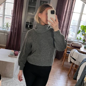 Grå stickad polotröja - Mysig grå stickad polotröja med hög krage och långa ärmar. Perfekt för kyliga dagar och ger en stilren look. Passar bra till både jeans och leggings.